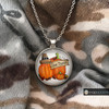 round snap jewelry pendant with two orange pumpkins, a pilgrim hat, autumn leaves, and a wooden sign reading Give Thanks on a silver chain