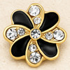 gold snap jewelry charm shaped like a flower with alternating black enamel and clear rhinestone petals