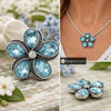 snap jewelry charm shaped like a flower with five light blue teardrop rhinestones and a clear center stone set in vintage gray metal with beaded detailing