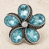 snap jewelry charm shaped like a flower with five light blue teardrop rhinestones and a clear rhinestone center set in vintage gray metal with beaded detailing