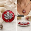 Red SnapAccents snap jewelry button featuring a detailed silver maple leaf design, perfect for fall and Canadian-themed accessories, displayed on a cozy plaid fabric background.
