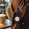 silver snap jewelry charm with a raised letter S on a white enamel background attached to a dark brown leather keychain fob with silver hardware