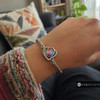 silver snap jewelry bracelet with a heart-shaped charm featuring a multicolor crystal center surrounded by clear rhinestones