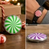 SnapAccents holiday snap jewelry buttons featuring red and white and green and white peppermint swirl designs, round metal snap charms, festive Christmas accessories, decorative interchangeable jewelry pieces on cozy knit background.