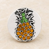 round silver snap jewelry charm with green and orange rhinestones arranged in a pineapple shape