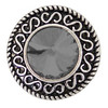 round snap jewelry charm with a faceted steel gray center gem and ornate silver scroll detailing around the edge