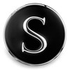 round snap jewelry charm with a polished silver letter S on a black enamel background and a silver rim engraved with SNAP ACCENTS