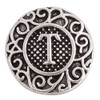 Round silver SnapAccents snap charm with intricate scrollwork design and raised letter "T" in the center, textured background, vintage-inspired jewelry accessory for customizable bracelets and necklaces.