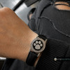 snap jewelry watch with a black leather band featuring a round snap charm with a black enamel background and a rhinestone paw print design