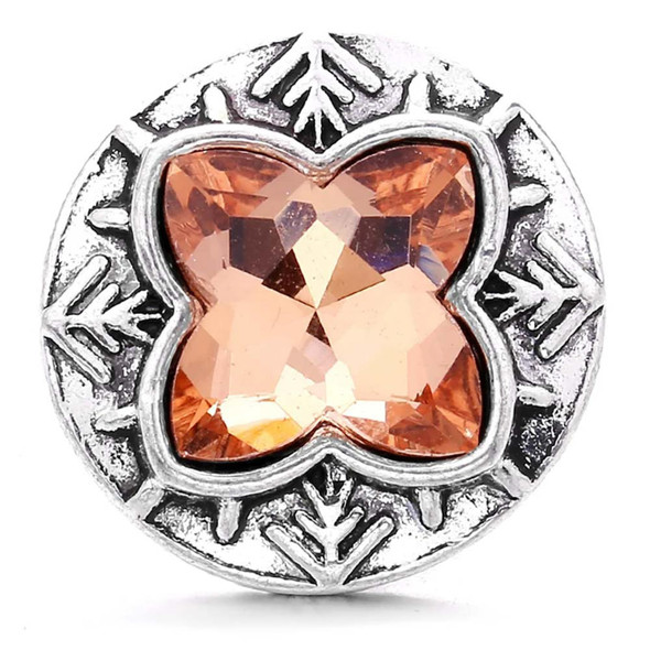 snap jewelry charm with a light brown four-point rhinestone set in a round silver-toned base with decorative arrow-like accents