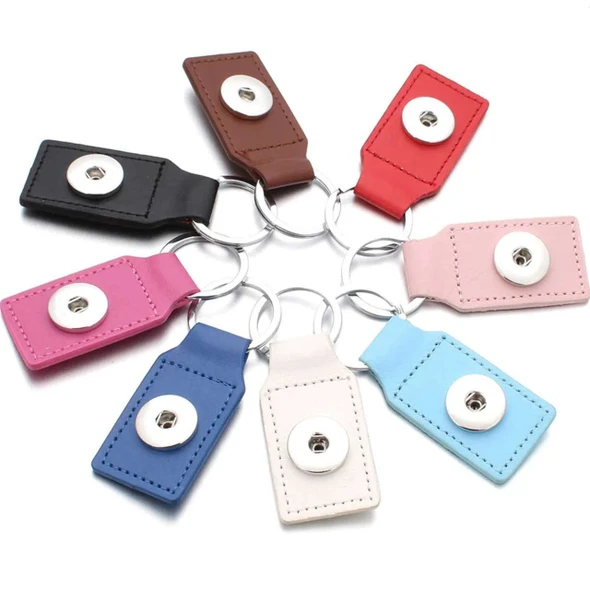 Leather snap jewelry keychain holders in assorted colors including black, brown, red, pink, blue, white, and light blue, featuring metal snap buttons and silver key rings, ideal for customizable snap charm accessories and stylish key organization.