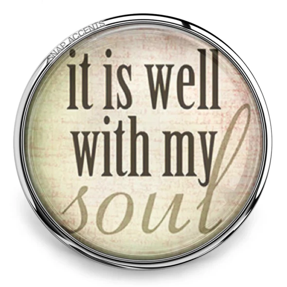 Round SnapAccents snap jewelry charm with inspirational quote "it is well with my soul" in black and beige text, silver metal frame, placed on wooden surface, ideal for interchangeable snap jewelry accessories.