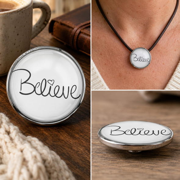 Round snap jewelry charm with the word Believe in black cursive and a small heart on a white background, shown loose and worn on a black cord necklace