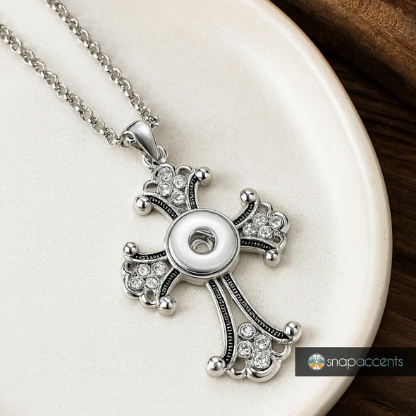 Silver cross pendant necklace with clear rhinestones and central snap button charm, SnapAccents snap jewelry accessory on silver chain, elegant religious statement jewelry for women, customizable snap charm holder, gift idea for faith-inspired fashion lovers.