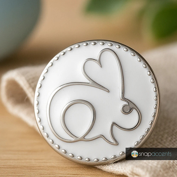 SnapAccents round snap jewelry charm featuring a minimalist silver outline of a rabbit on a white background, decorative beaded edge, interchangeable snap button accessory for bracelets, necklaces, and fashion jewelry, perfect for animal lovers and spring-themed style.