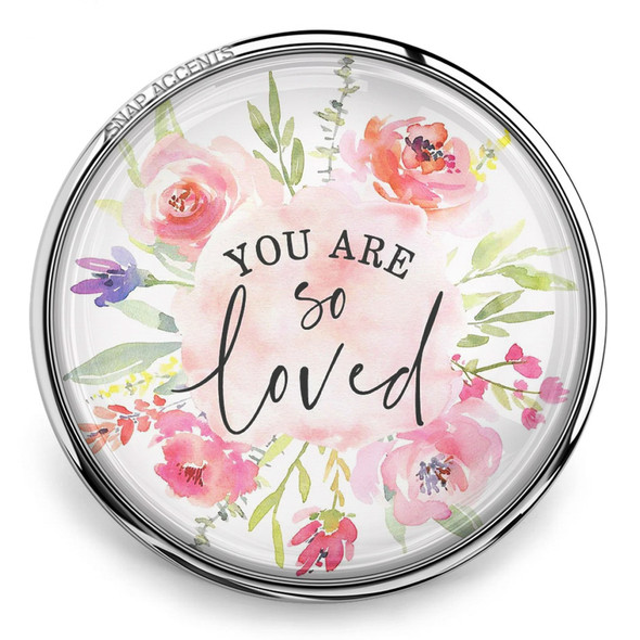 round snap jewelry charm with a silver metal edge featuring watercolor pink and purple flowers surrounding the words You Are So Loved in black script