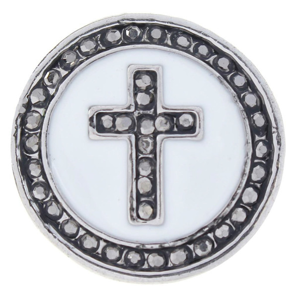 round snap jewelry charm with a white enamel background featuring a gray rhinestone cross and a border of gray rhinestones