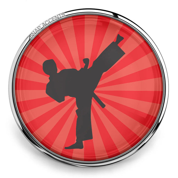SnapAccents snap jewelry featuring a black silhouette of a martial artist performing a high kick on a vibrant red background with radiating stripes, encased in a shiny silver metal frame, perfect for martial arts enthusiasts and sports-themed accessories.