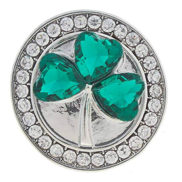 round snap jewelry charm with a silver base featuring a shamrock made of three green heart-shaped rhinestones surrounded by clear crystal rhinestones