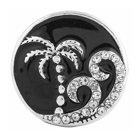 round snap jewelry charm with a silver palm tree and rhinestone-studded waves on a black enamel background