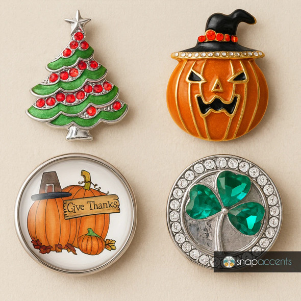 SnapAccents seasonal snap jewelry set featuring a green Christmas tree with red gems, a Halloween pumpkin with a witch hat, a "Give Thanks" Thanksgiving pumpkin design, and a silver-tone shamrock with green gems and clear rhinestones, perfect for interchangeable snap charm bracelets and accessories.