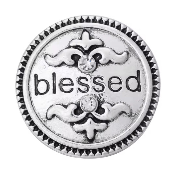 Silver-tone round snap jewelry charm with the word blessed, two clear rhinestones, and decorative scroll designs