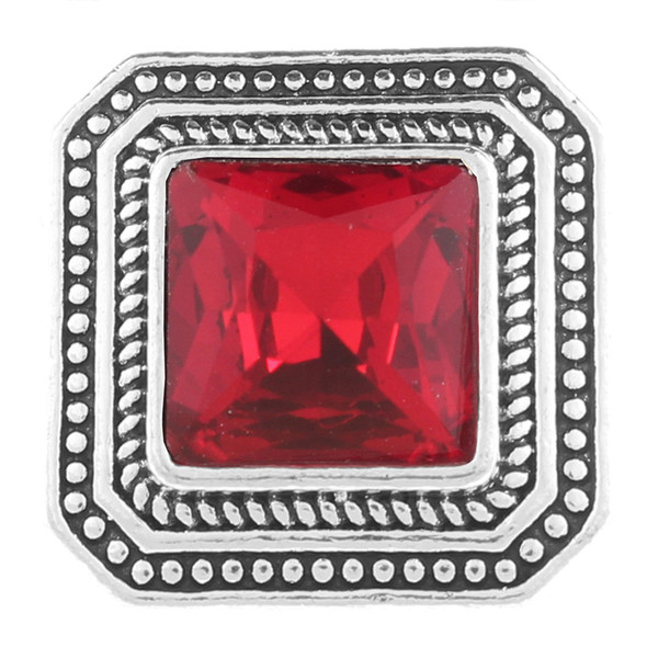 square snap jewelry charm with a red faceted center stone and decorative silver-tone border featuring beaded and twisted rope details