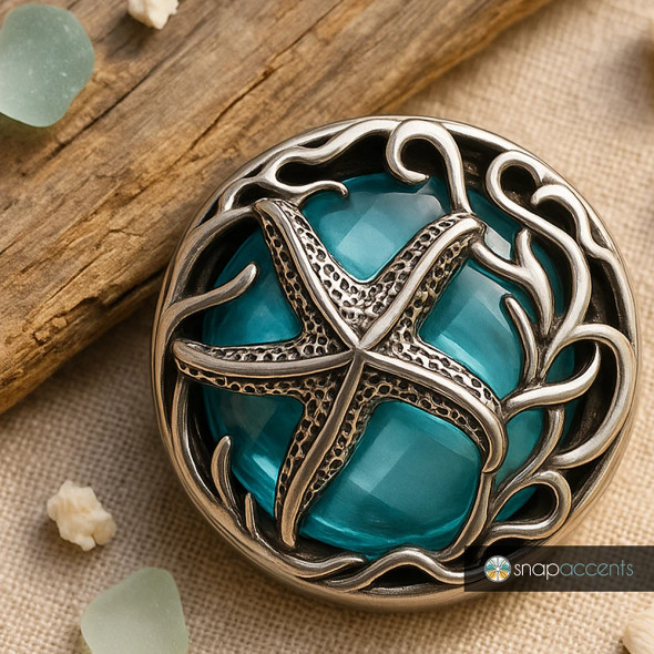 SnapAccents snap jewelry featuring a detailed silver starfish design over a faceted turquoise blue glass center, surrounded by intricate silver seaweed accents, perfect for interchangeable snap charm bracelets and necklaces, beach-themed accessory, ocean-inspired fashion jewelry piece.