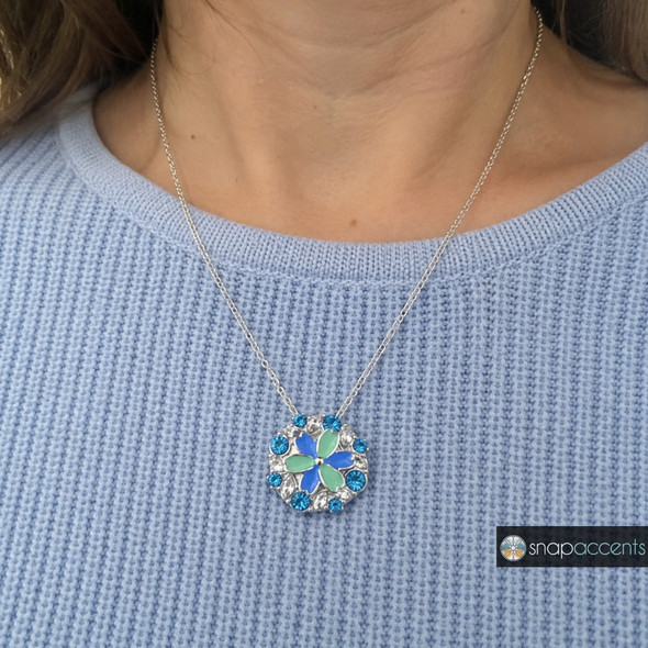 silver snap jewelry necklace with a round pendant featuring teal and blue flower petals surrounded by blue and clear rhinestones