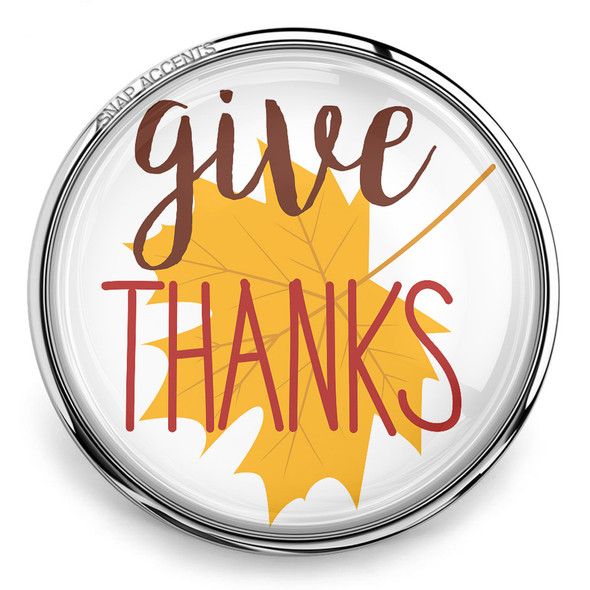 round snap jewelry charm with a yellow maple leaf and the words give THANKS in brown and red script inside a silver metal frame
