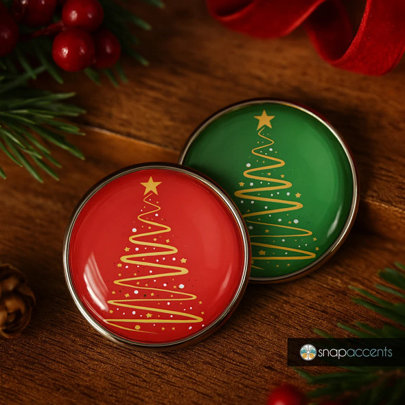 Christmas snap jewelry buttons with gold stylized tree design on red and green backgrounds, festive holiday accessory by SnapAccents, decorative snap charms for bracelets and necklaces, seasonal gift idea, wooden surface with holiday greenery and red berries.