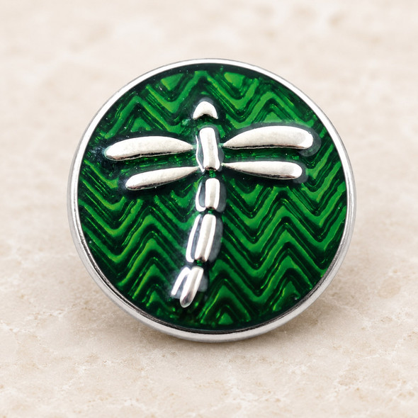 green snap jewelry charm with silver dragonfly over textured chevron background