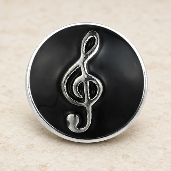 round snap jewelry charm with black enamel background and raised silver treble clef symbol