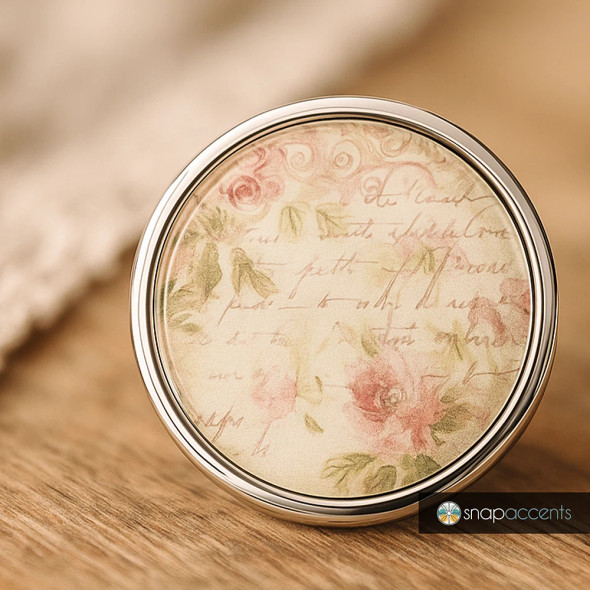 Round SnapAccents snap jewelry charm with vintage floral design and cursive script, featuring soft pink roses and green leaves in a silver-tone metal frame, ideal for interchangeable snap jewelry accessories.