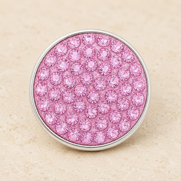round snap jewelry charm covered with multiple light pink rhinestones set in a silver-tone metal base