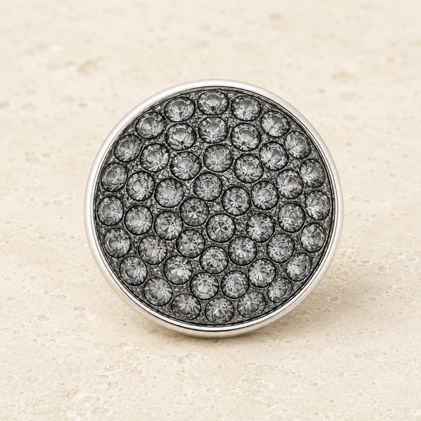 round snap jewelry charm covered with multiple small gray rhinestones set in a silver-tone metal base