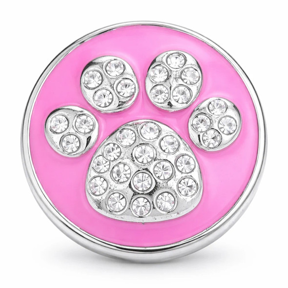 Round SnapAccents snap jewelry charm with pink enamel background and silver paw print adorned with clear rhinestones, interchangeable accessory for snap bracelets and necklaces, stylish pet-themed fashion piece.