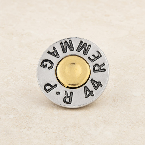 silver and gold-toned snap jewelry charm resembling a bullet casing with engraved text around the edge