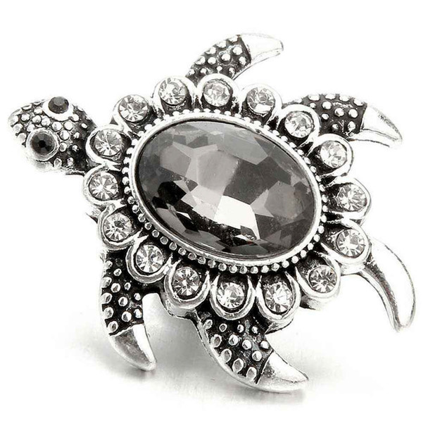 Gray sea turtle snap jewelry charm with a large faceted dark gray rhinestone center and smaller clear rhinestones around the edges