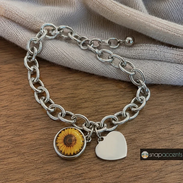 Silver chain link bracelet with interchangeable snap charms, featuring a round donut and heart-shaped charm, stylish customizable jewelry accessory by SnapAccents.
