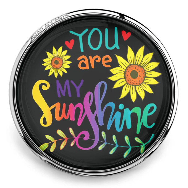 SnapAccents colorful snap jewelry charm with "You are my sunshine" text, bright sunflowers, hearts, and decorative leaves on black background, perfect for personalized bracelets and accessories.