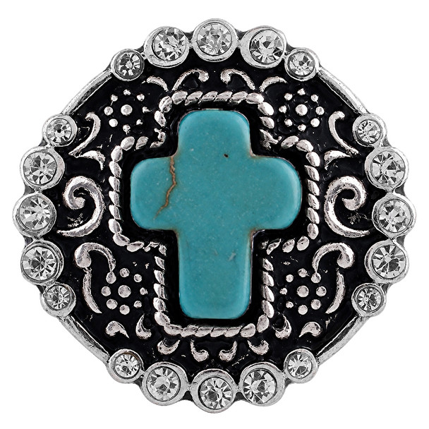 round snap jewelry charm with a turquoise stone cross center, surrounded by silver-toned filigree and clear rhinestones on a black background