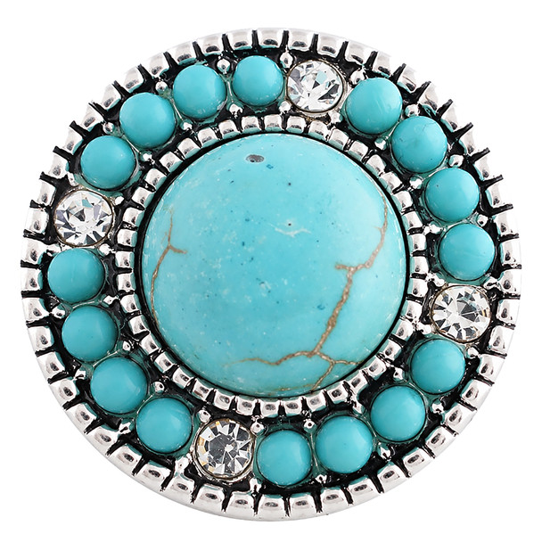 round snap jewelry charm with a large central turquoise stone surrounded by smaller turquoise beads and clear rhinestones in a silver-toned setting
