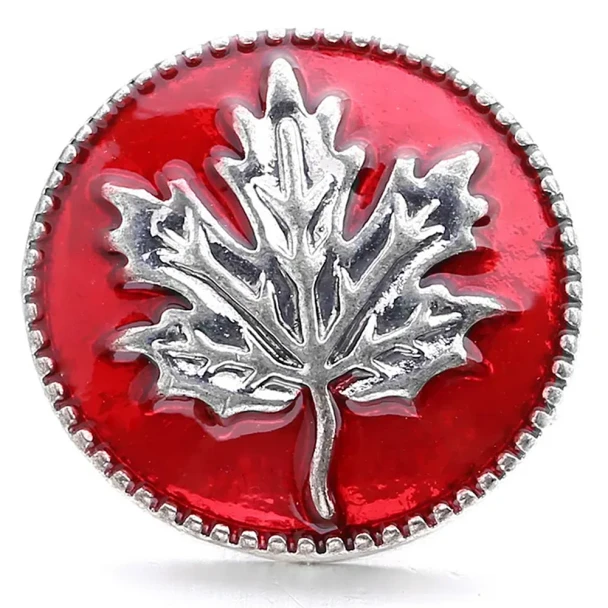 Red SnapAccents snap jewelry button featuring a detailed silver maple leaf design, perfect for fall and Canadian-themed accessories, displayed on a cozy plaid fabric background.