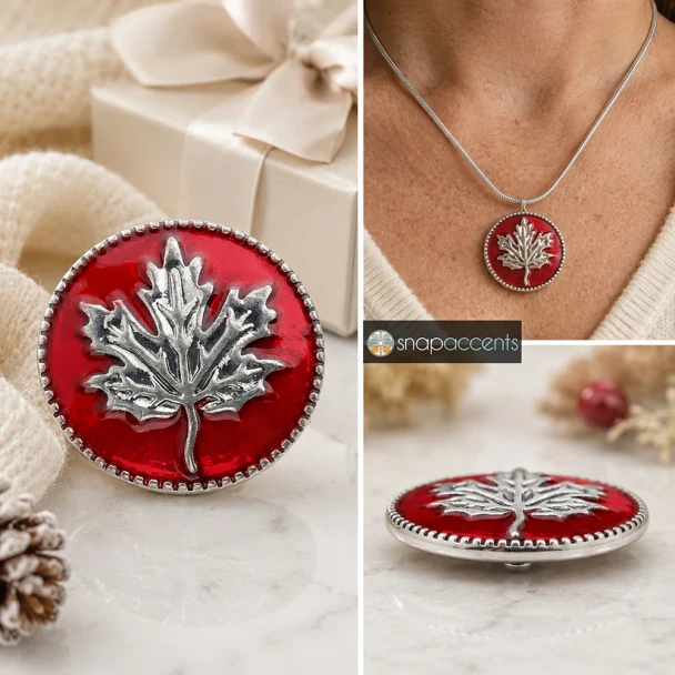 Red SnapAccents snap jewelry button featuring a detailed silver maple leaf design, perfect for fall and Canadian-themed accessories, displayed on a cozy plaid fabric background.