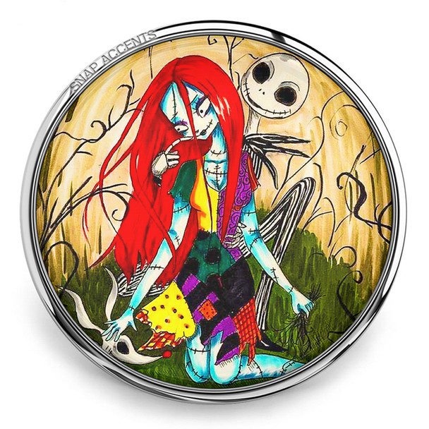 18MM snap jewelry charm featuring a colorful illustration of Sally with bright red hair and patchwork dress kneeling with Jack Skellington behind her in a whimsical background