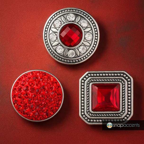 SnapAccents snap jewelry set featuring three interchangeable snap charms with vibrant red gemstones and intricate silver-tone metal designs, including a round faceted gem with clear accents, a cluster of small red crystals, and a square red gem with detailed beaded border, perfect for customizable fashion accessories and statement jewelry pieces.