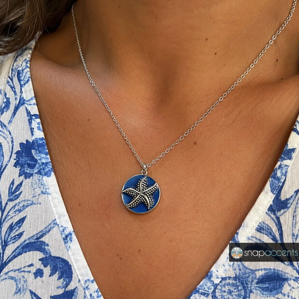 silver-tone starfish snap jewelry charm on a deep blue enamel background displayed on a silver chain necklace