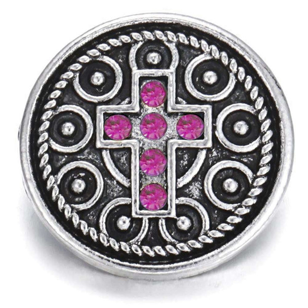 Round silver snap charm with intricate circular patterns and a central cross adorned with seven bright pink rhinestones, designed for SnapAccents snap jewelry collections.