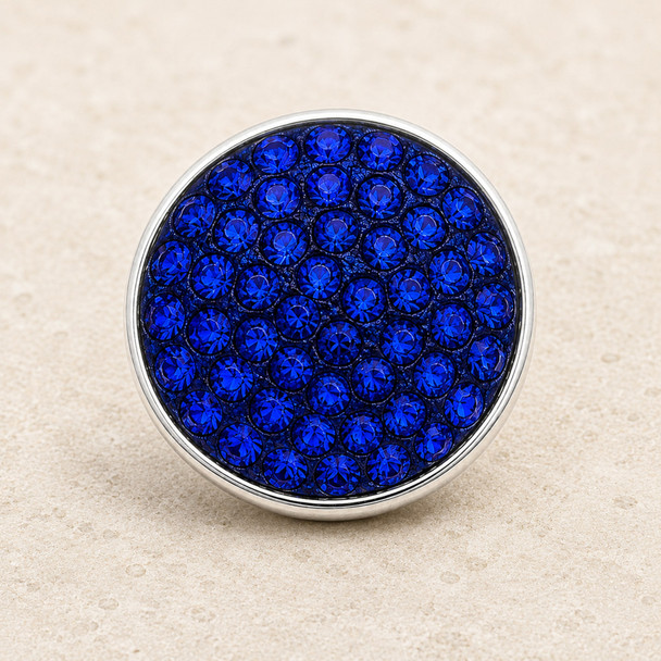 round snap jewelry charm covered with multiple royal blue rhinestones set in a silver-tone metal base